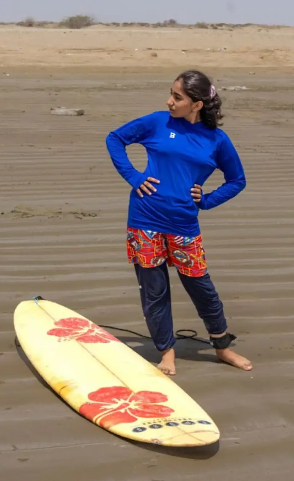 ورزشکار دختر باشگاه رمین در کنار ساحل آماده موج‌سواری