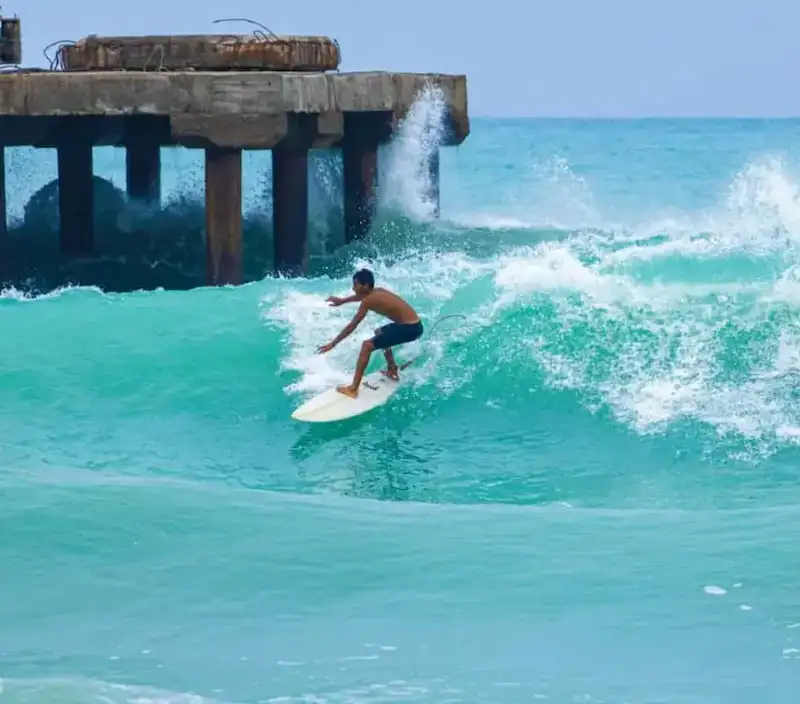 باشگاه موج‌سواری رمین - پسر جوان در حال موج‌سواری